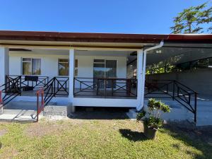 a house with a porch with a table on it at Tevaatua house in Papara