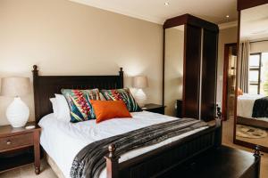 a bedroom with a large bed with colorful pillows at 2 Zebra View, Cathkin Estate in Winterton