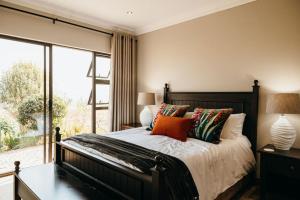 a bedroom with a bed and a large window at 2 Zebra View, Cathkin Estate in Winterton +48 photos
