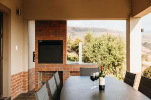 a table with two glasses of wine on a patio at 2 Zebra View, Cathkin Estate in Winterton