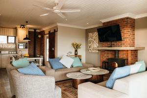 a living room with two couches and a fireplace at 2 Zebra View, Cathkin Estate in Winterton