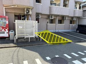 a yellow barricade on a street in front of a building at アルゴ境川 in Kitakyushu