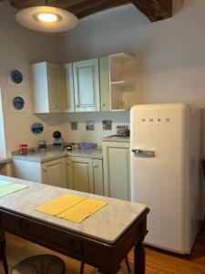 a kitchen with white cabinets and a white refrigerator at Casa la Mirage 6 in Bozzolo +8 photos