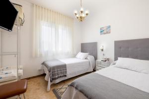 a white bedroom with two beds and a window at MM Delta Holidays in El Lligallo del Gànguil +24 photos