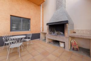 a patio with a fireplace and a table and chairs at MM Delta Holidays in El Lligallo del Gànguil