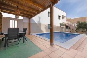 a patio with a swimming pool and a table and chairs at MM Delta Holidays in El Lligallo del Gànguil
