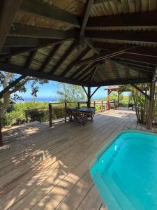 a wooden deck with a pool and a picnic table at Bambou cabane intimiste in Saint-Louis