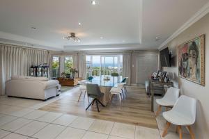a living room with a couch and a table and chairs at Seaview Manor Exquisite Bed & Breakfast in Durban