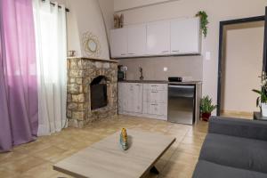 a living room with a kitchen and a fireplace at Mani Spot Casa Elia in Areopoli