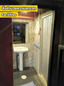 a bathroom with a sink and a mirror at The 25 Hostel in Sathani Khlong Rian