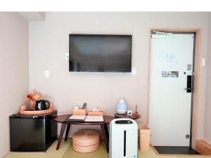 a room with a table and a tv on the wall at 灯光旅館 Light hotel in Tokyo