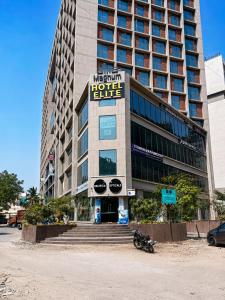 a hotel building with a motorcycle parked in front of it at Hotel Elite in Ahmedabad