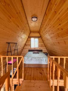 a bedroom in a wooden cabin with a bed in it at Cottages in Kobuleti