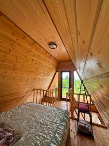 a bedroom with a bed in a wooden room at Cottages in Kobuleti