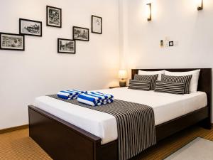 a bedroom with a large bed with pillows on it at Coco Palm Villa and Cabanas in Tangalle +51 photos