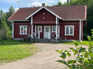 a red house with a picnic table in front of it at Lomakivi in Kausala