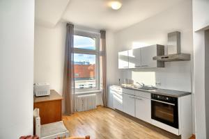a kitchen with white cabinets and a large window at 2 bedrooms & free parking in Vienna