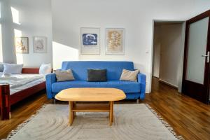a living room with a blue couch and a coffee table at 2 bedrooms & free parking in Vienna