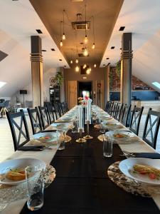 a long dining room with a long table with plates of food at Agroturystyka Myślinów - Black Horse Bar&Grill in Męcinka