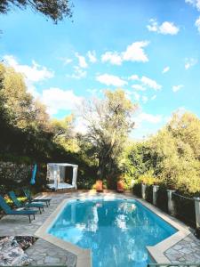 a swimming pool in a yard with two chairs at Small chalet in Serriera +3 photos