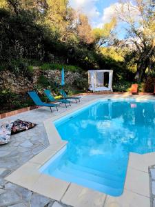 a swimming pool with two chairs and a table at Small chalet in Serriera