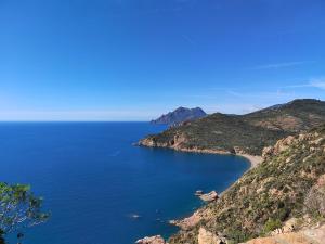 a view of the ocean from a cliff at Small chalet in Serriera