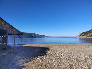 a beach with a shack and the water at Small chalet in Serriera