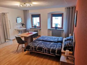 a bedroom with a bed and a table and chairs at Pension am Kirchberg - Zimmer 1 in Daun