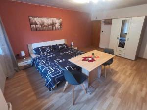 a bedroom with a bed and a wooden table at Pension am Kirchberg - Zimmer 1 in Daun