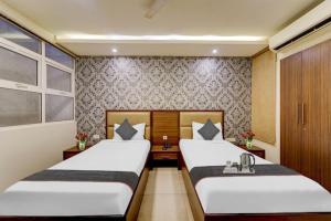 two beds in a hotel room with two beds sidx sidx sidx at RG Suites - Royapettah in Chennai
