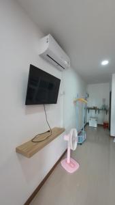 a living room with a flat screen tv on a wall at ปลายเขื่อนแคมปิ้ง บ้านวิวเขื่อน in Sirindhorn