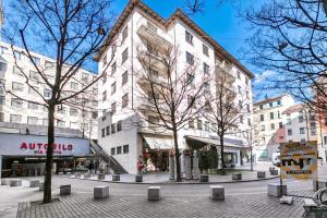 a large white building on a city street with trees at Novos Contrada in Lugano +76 photos