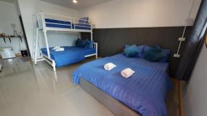 a bedroom with two beds and a bunk bed at ปลายเขื่อนแคมปิ้ง บ้านวิวเขื่อน in Sirindhorn