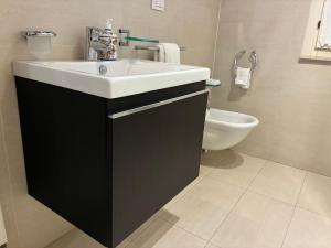 a bathroom with a white sink and a toilet at Casa la Mirage 6 in Bozzolo