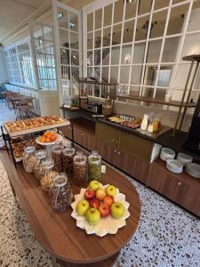 a table with fruits and other food items on it at Flore Hôtel & Jardin The Originals Relais in Vichy