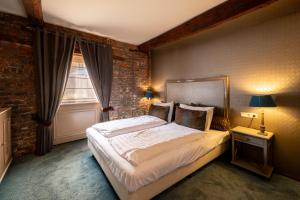 a bedroom with a bed and a brick wall at Hotel Schinvelder Hoeve in Schinveld