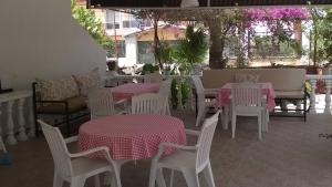 a restaurant with white tables and chairs with pink and white table cloth at Garden-view suite room in Ortaca