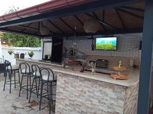 a patio with a bar with stools and a tv at Garden-view suite room in Ortaca