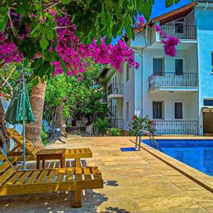 a resort with a swimming pool and a building at Garden-view suite room in Ortaca