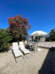a group of chairs and a table and an umbrella at Anita room in Kotor