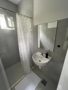 a white bathroom with a sink and a mirror at Anita room in Kotor