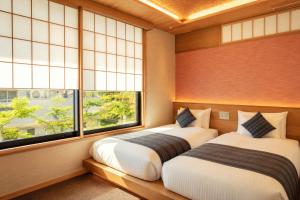 two beds in a room with two windows at MR T Kamogawa East 12 in Kyoto +78 photos