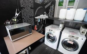 a kitchen with a washing machine and a microwave at Coller Boutique Hostel in Singapore +63 photos
