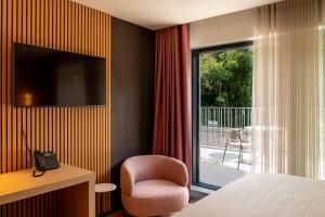 a room with a bed and a chair and a window at Hotel Mardaga in As