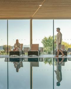 a man walking in front of a table with a woman at Wellnesshotel Linde in Sulzberg