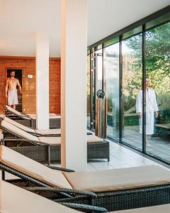 two men in a bath room with sliding glass doors at Wellnesshotel Linde in Sulzberg
