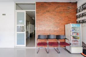 a group of stools in front of a brick wall at Nipa Guest House near Universitas Widyagama Mitra RedDoorz in Blimbing
