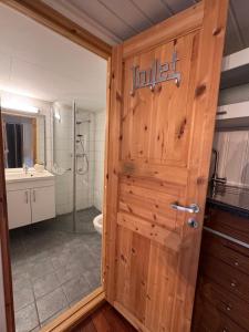 a bathroom with a toilet and a wooden door at Sweet home in Kristiansund +6 photos