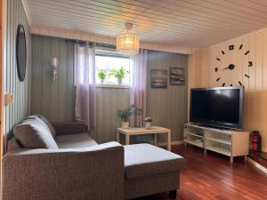 a living room with a couch and a flat screen tv at Sweet home in Kristiansund
