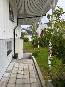 an outdoor walkway leading to a house with a refrigerator at Sweet home in Kristiansund